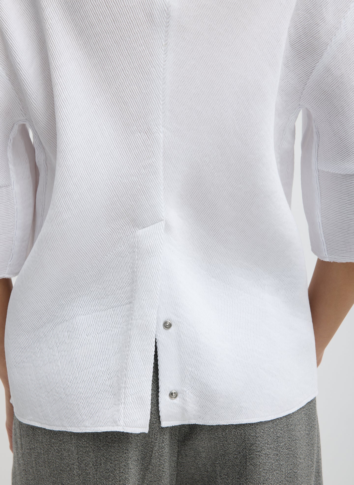 White Viscose Plisse Hinged Short Sleeve Top - closeup of snaps at hem