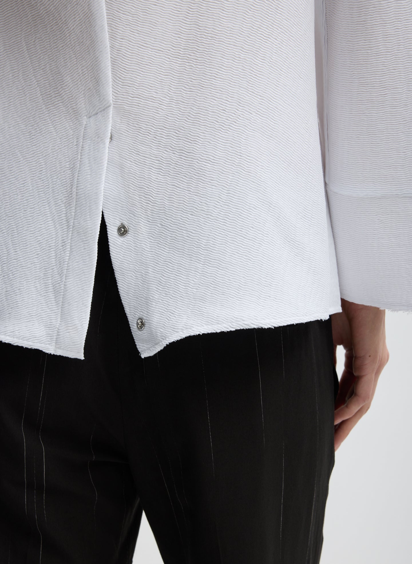 White Viscose Plisse Hinged Long Sleeve Top - closeup of snap details at hem