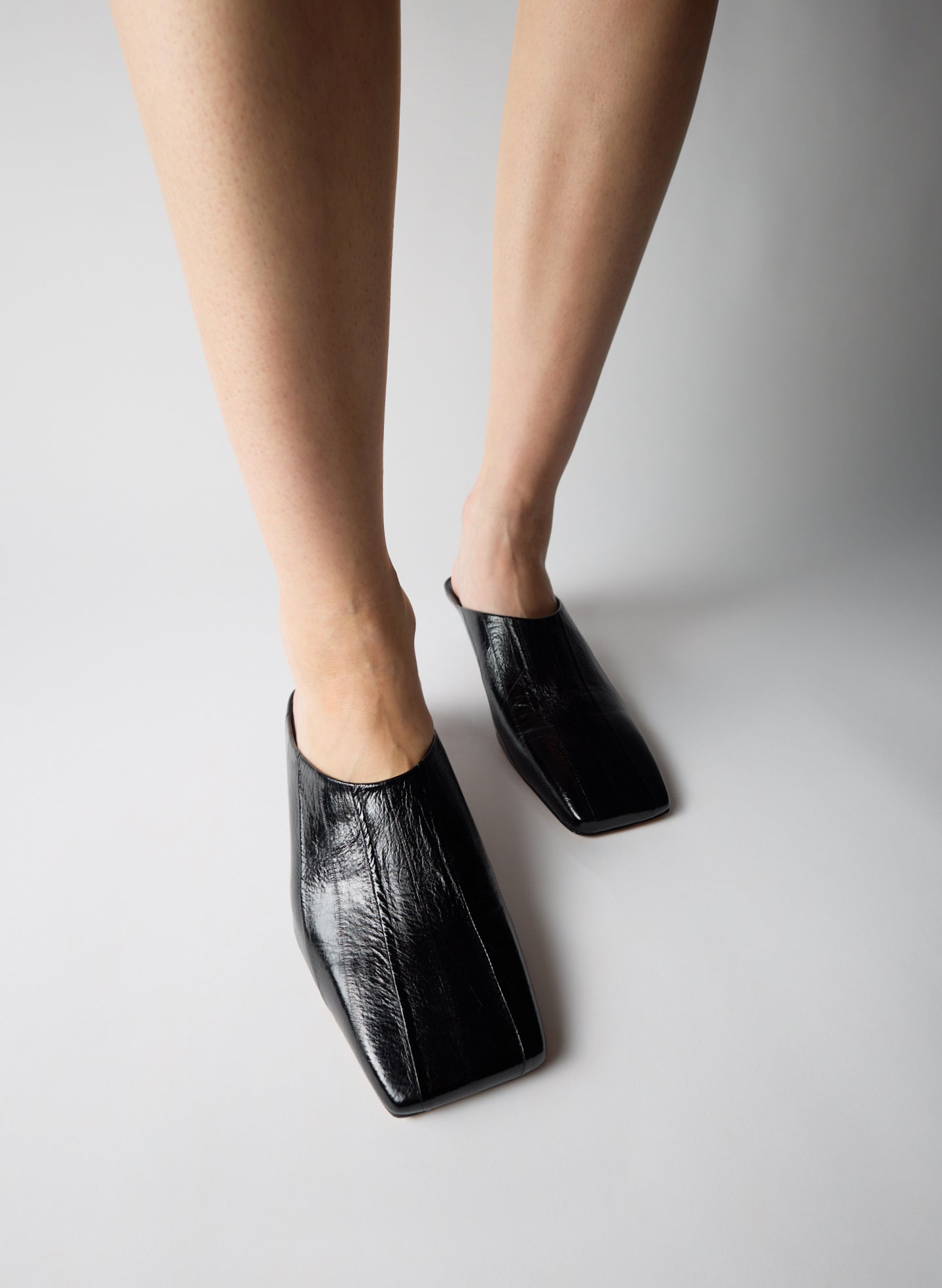 Black Eel Skin Gwinnett Heeled Mules - on model