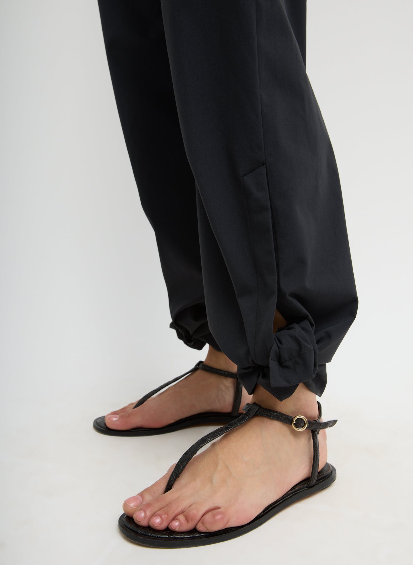 Black Tech Suiting Mark Trouser - closeup of tied hem detail
