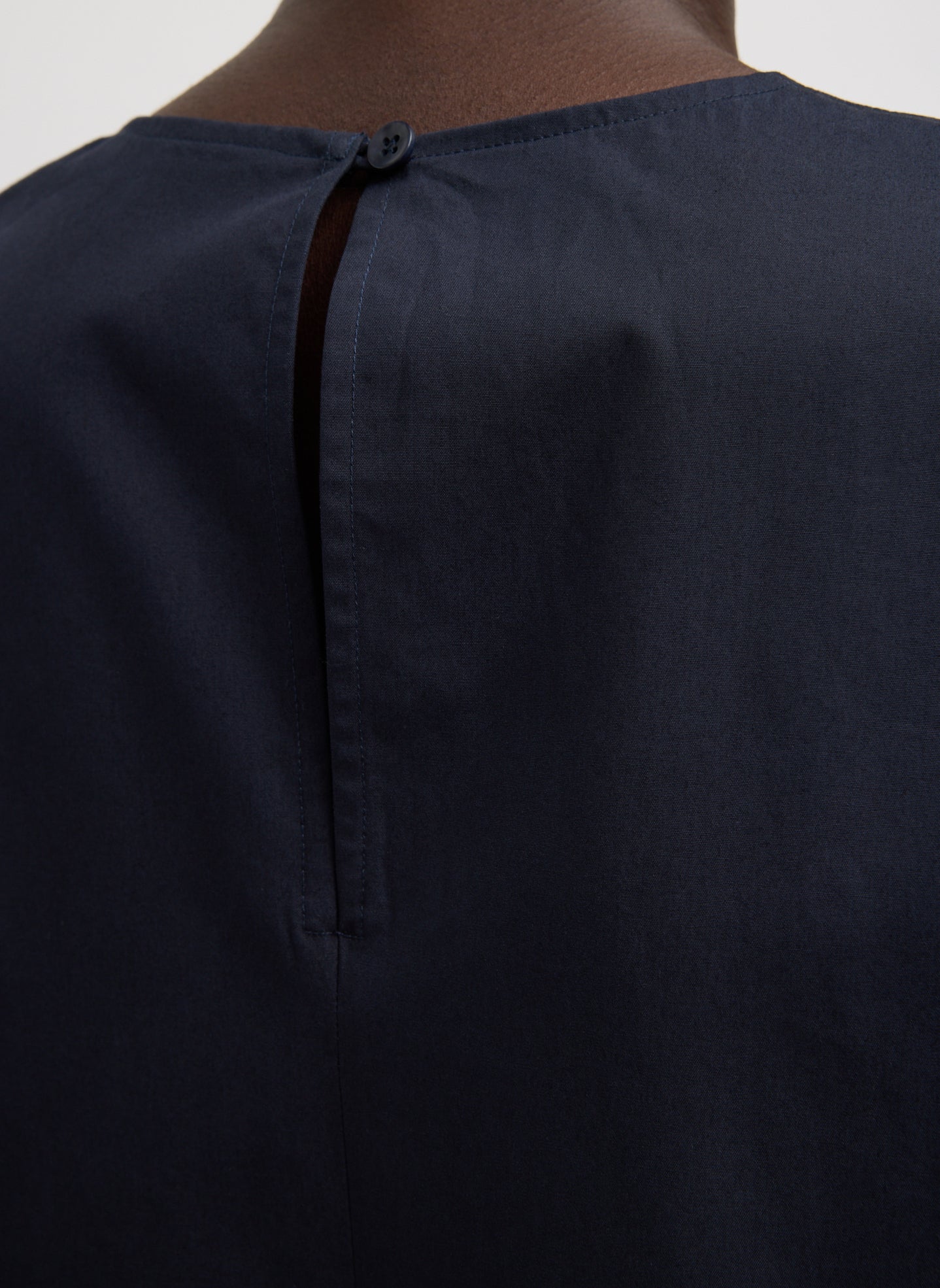 Navy Compact Eco Poplin Reverse Sleeve Top - closeup of back button closure