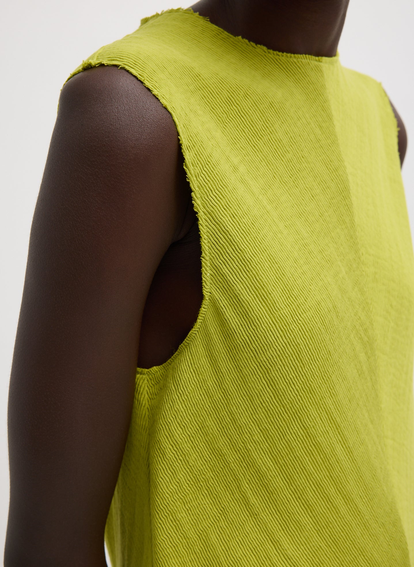 Chartreuse Viscose Plisse Sleeveless Bias Short Tunic - closeup of raw neckline
