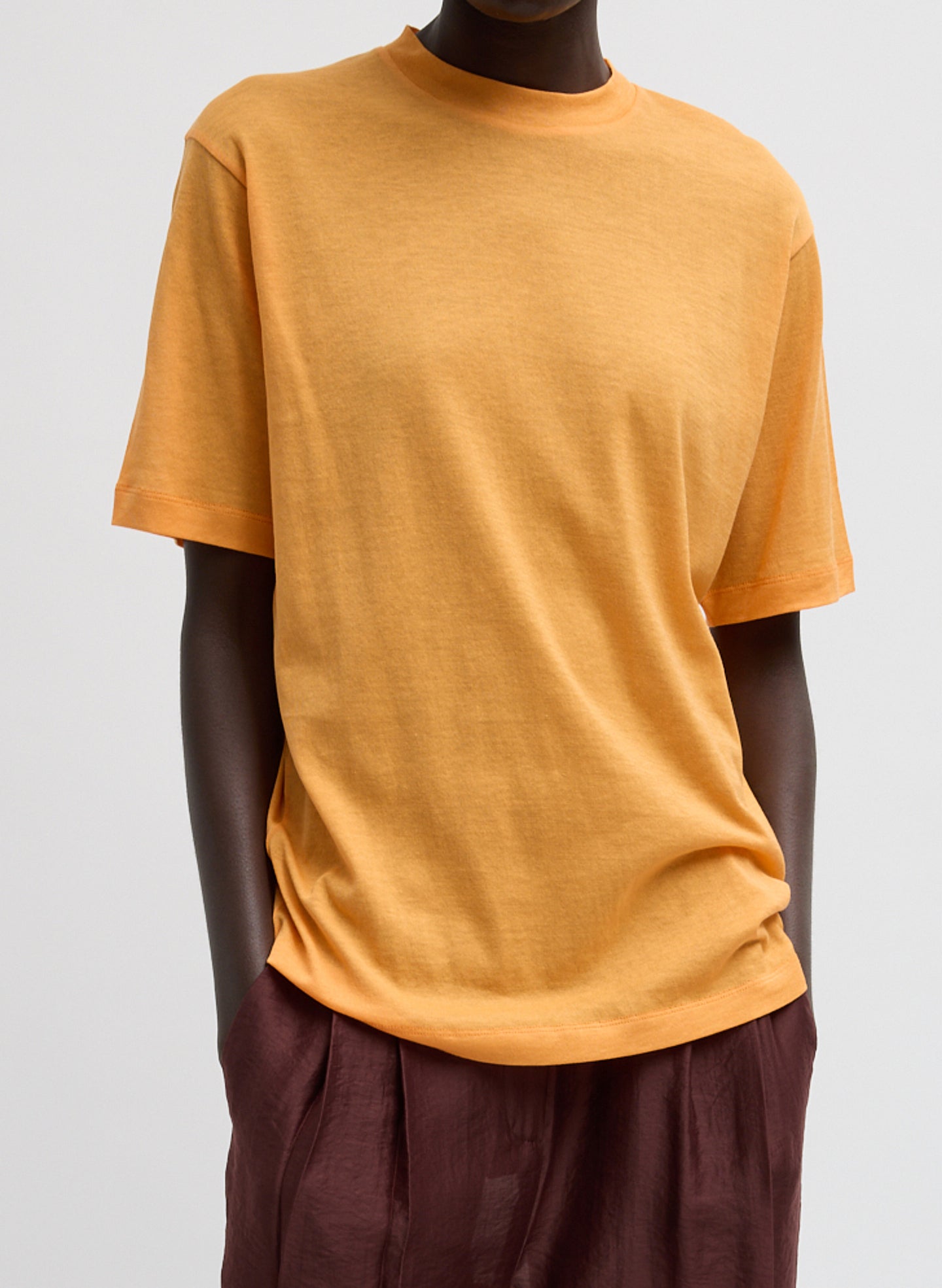 Sheer Crepe Knit Mock Unisex T-Shirt - Orange Sheer Crepe Knit Mock Neck Unisex T-Shirt - front view on model
