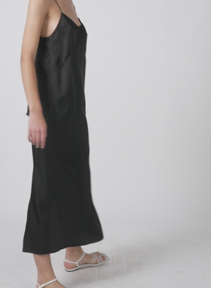 Model wearing the the slip skirt black 1 walking forward and turning around