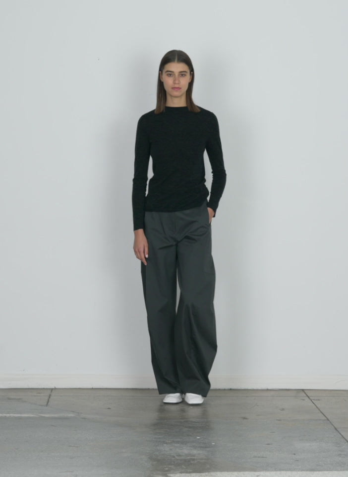 Model wearing the skinlike mercerized wool soft sheer pullover charcoal walking forward and turning around