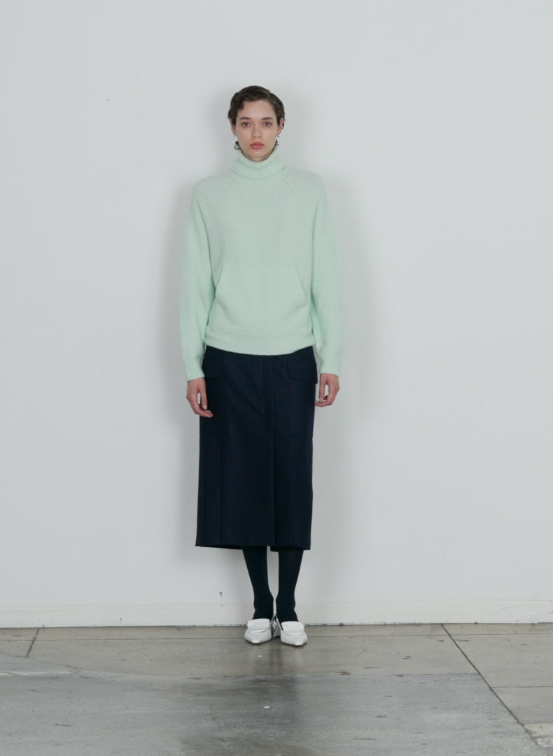 Model wearing the douillet tneck easy pullover pale mint walking forward and turning around