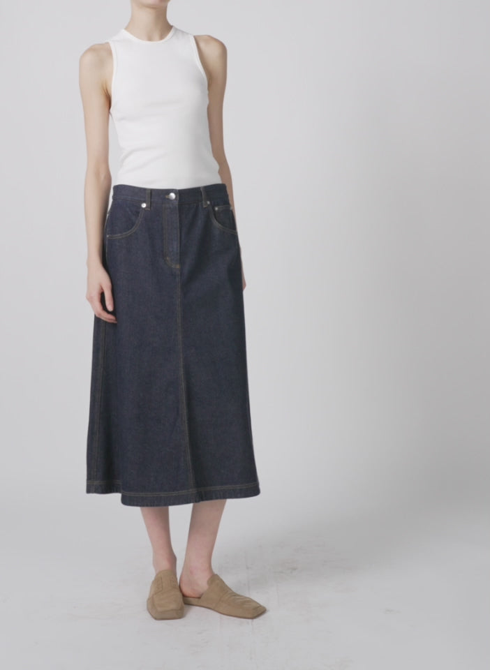 Model wearing the indigo denim midi a-line skirt dark denim walking forward and turning around