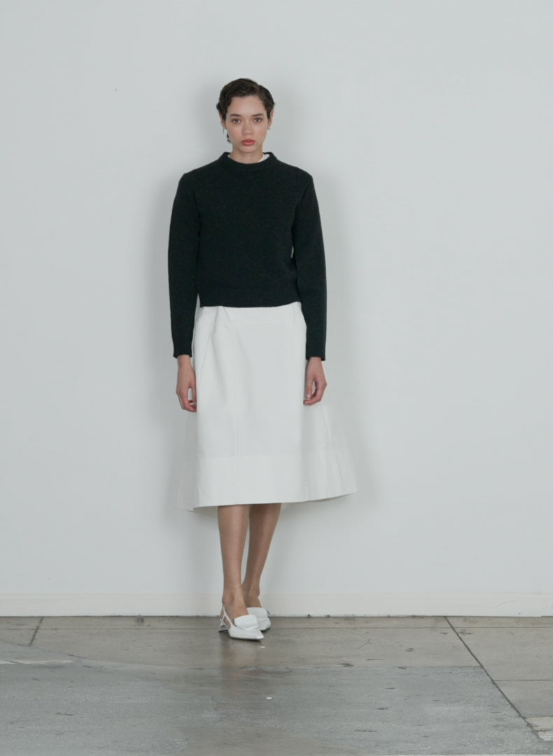 Model wearing the sculpted cotton skirt white walking forward and turning around