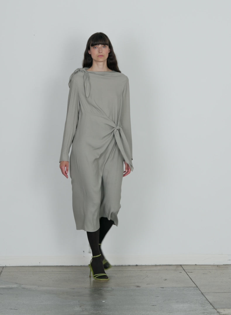 Model wearing the feather weight eco crepe benedict dress grey walking forward and turning around
