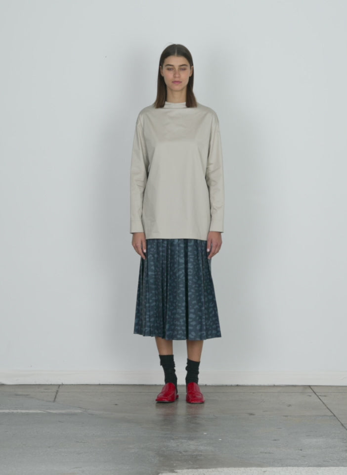 Model wearing the eco poplin funnelneck top ash walking forward and turning around
