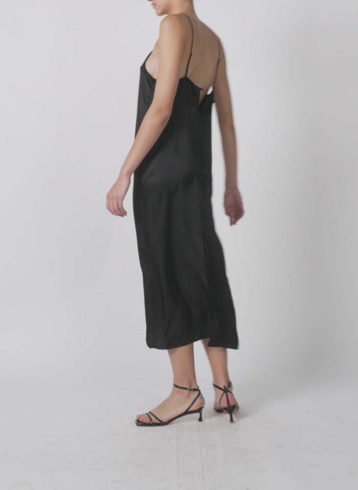 Model wearing the the slip dress black 1 walking forward and turning around