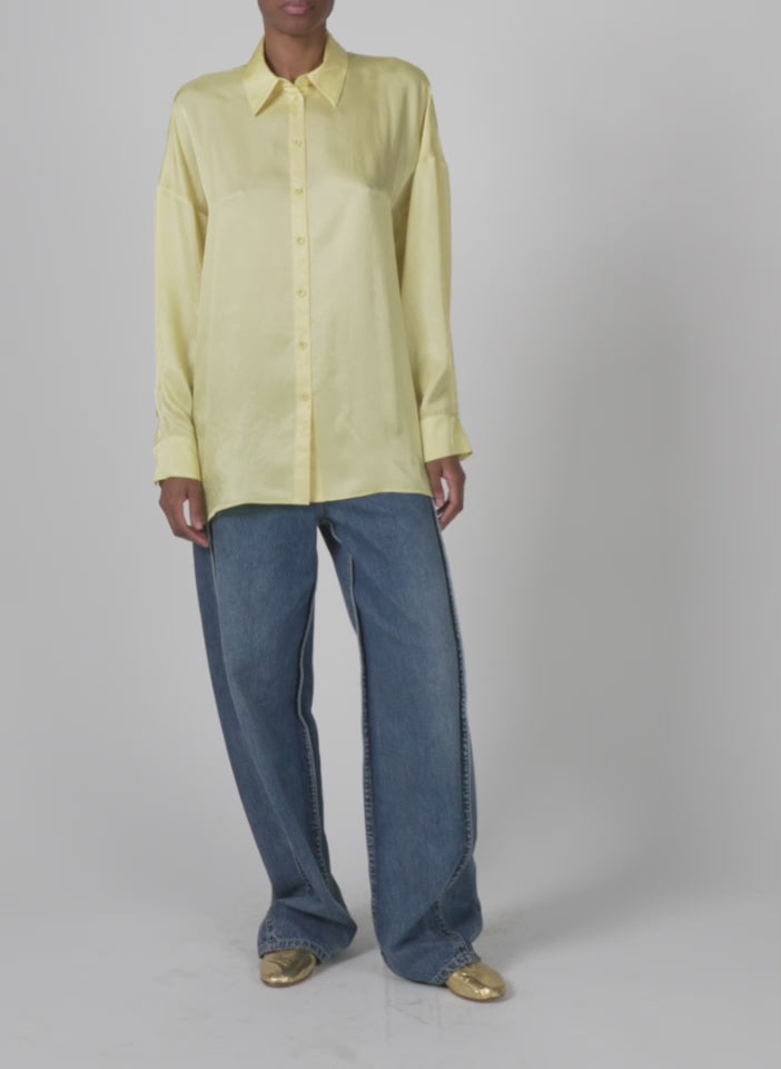 Model wearing the spring acetate shirt w cocoon back yellow walking forward and turning around