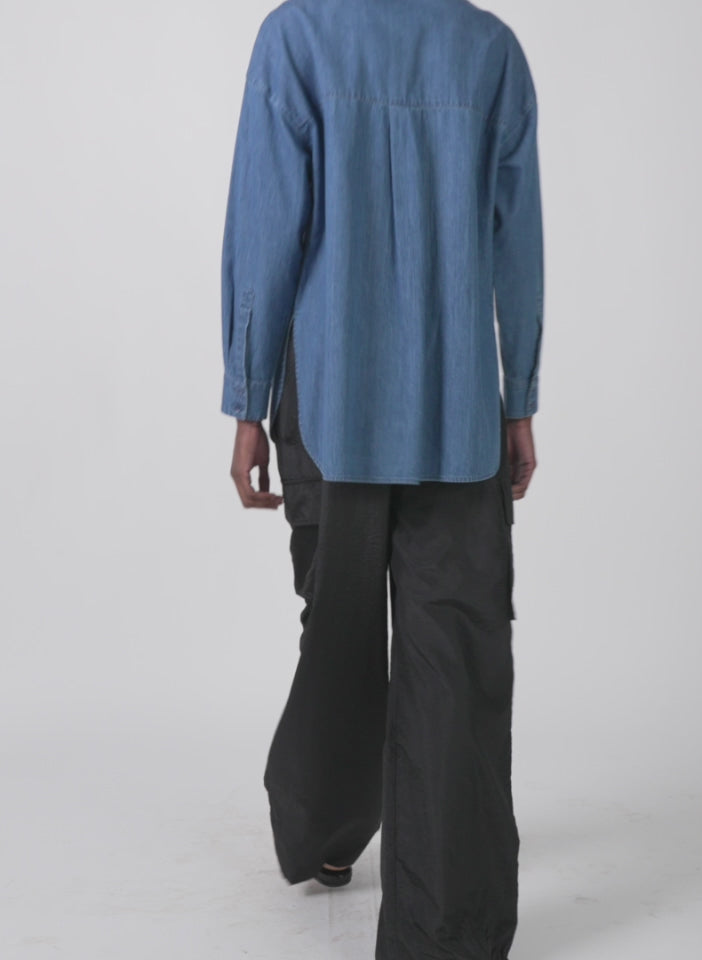 Model wearing the light weight stone wash denim tuxedo shirt denim blue walking forward and turning around