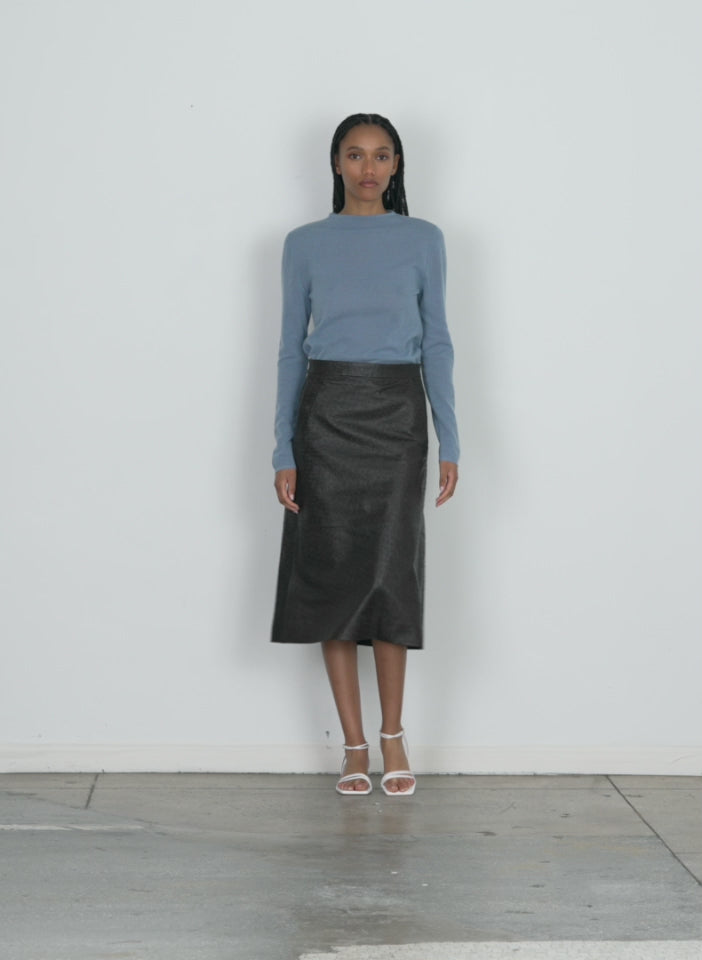 Model wearing the ostrich leather a-line skirt dark brown walking forward and turning around