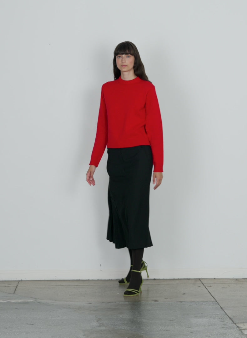 Model wearing the soft lambswool shrunken crewneck pullover red walking forward and turning around