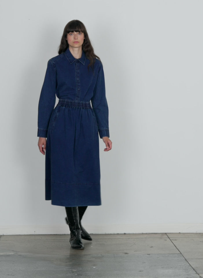 Model wearing the tencel cotton pull on full skirt blue walking forward and turning around