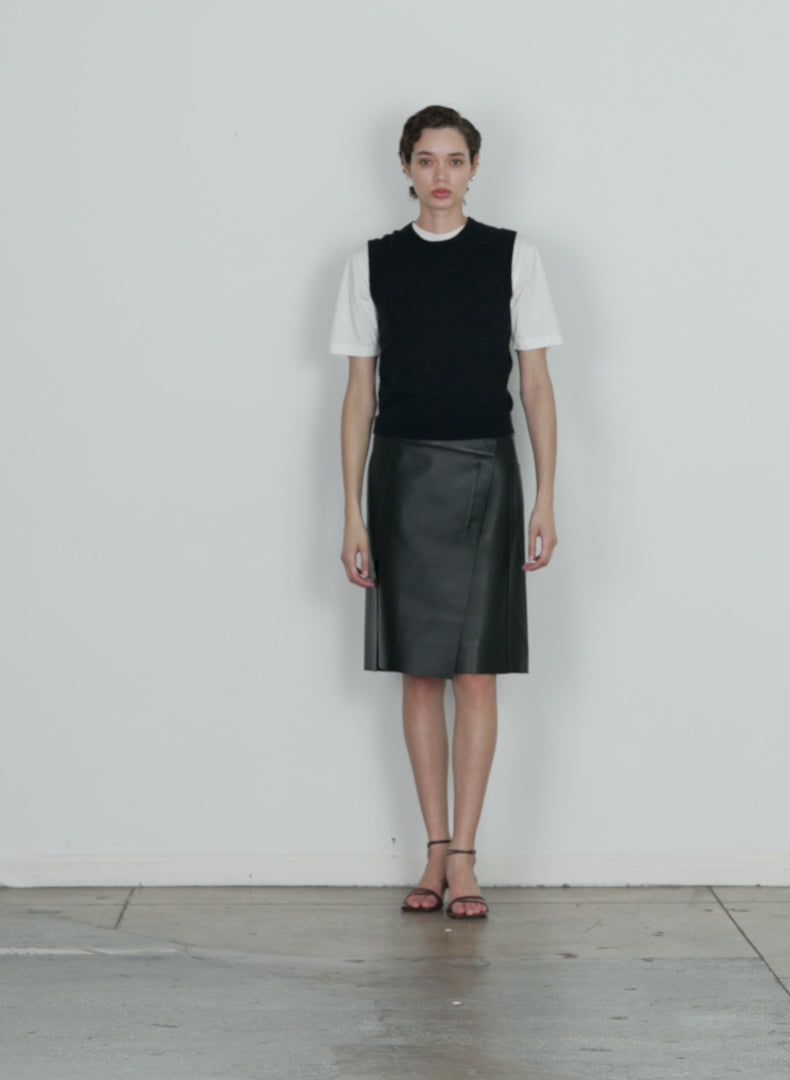 Model wearing the bonded leather slash skirt black walking forward and turning around