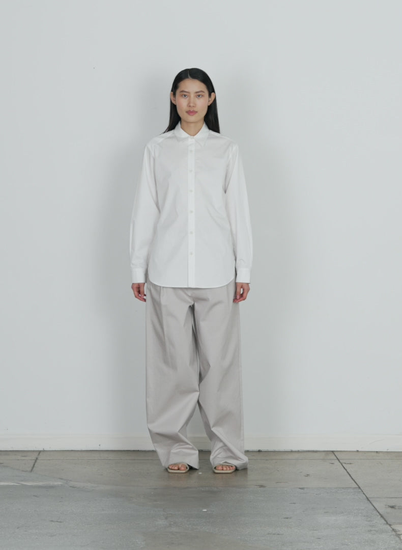 Model wearing the eco poplin shirt with inseam vent white walking forward and turning around
