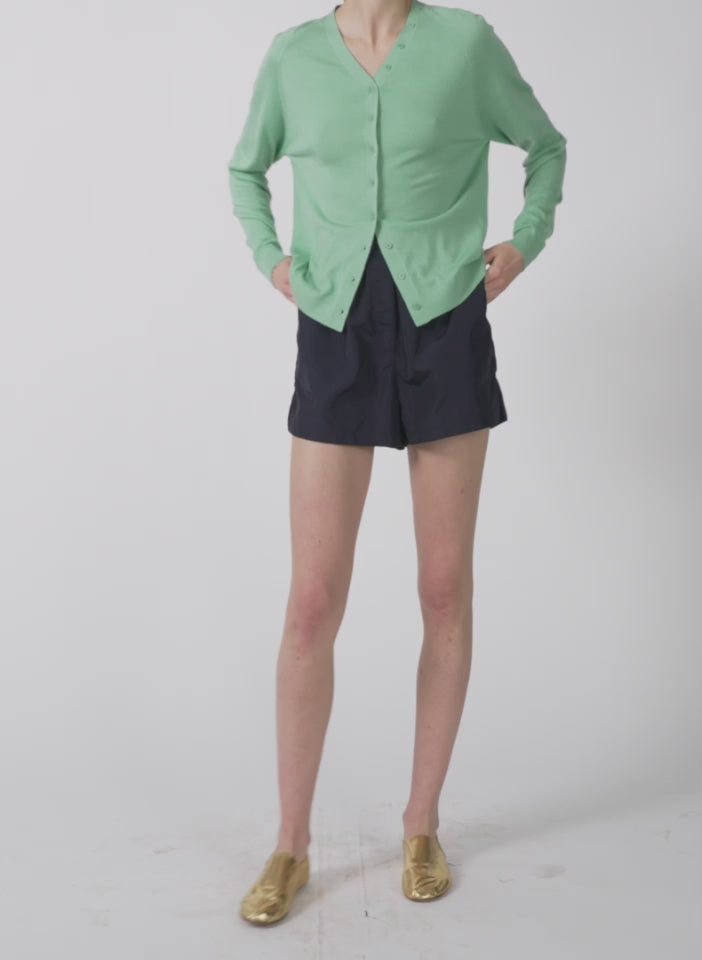 Model wearing the cashmere silk blend slim cardigan green tea walking forward and turning around