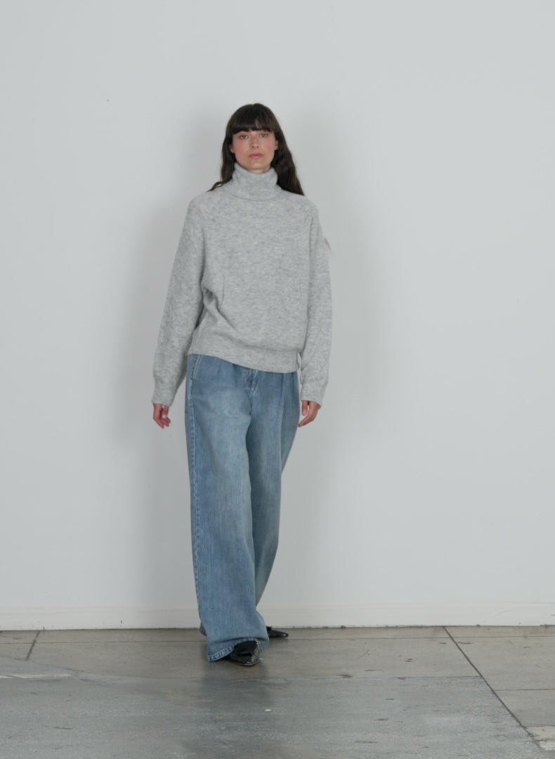 Model wearing the douillet tneck easy pullover light heather grey walking forward and turning around