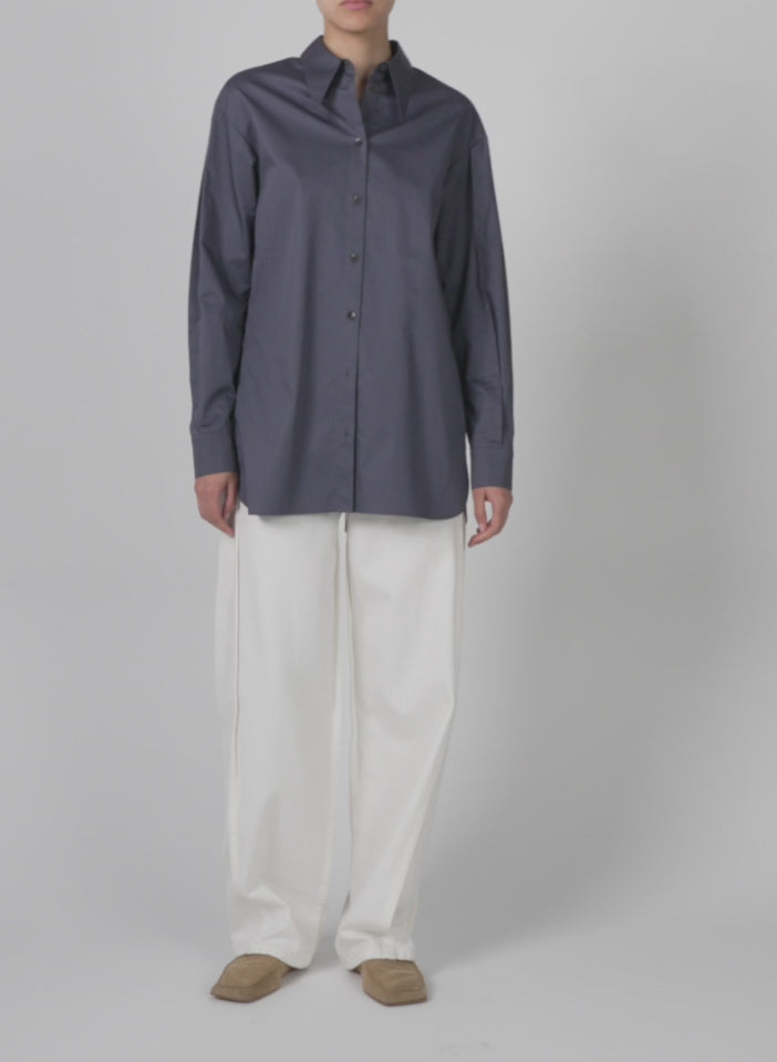 Model wearing the eco poplin shirt with tucked sleeve shark grey walking forward and turning around