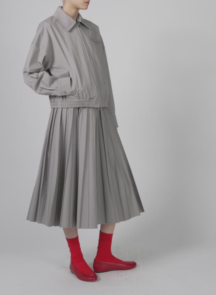 Model wearing the oliver cotton stretch tricotine pintucked skirt grey moon walking forward and turning around