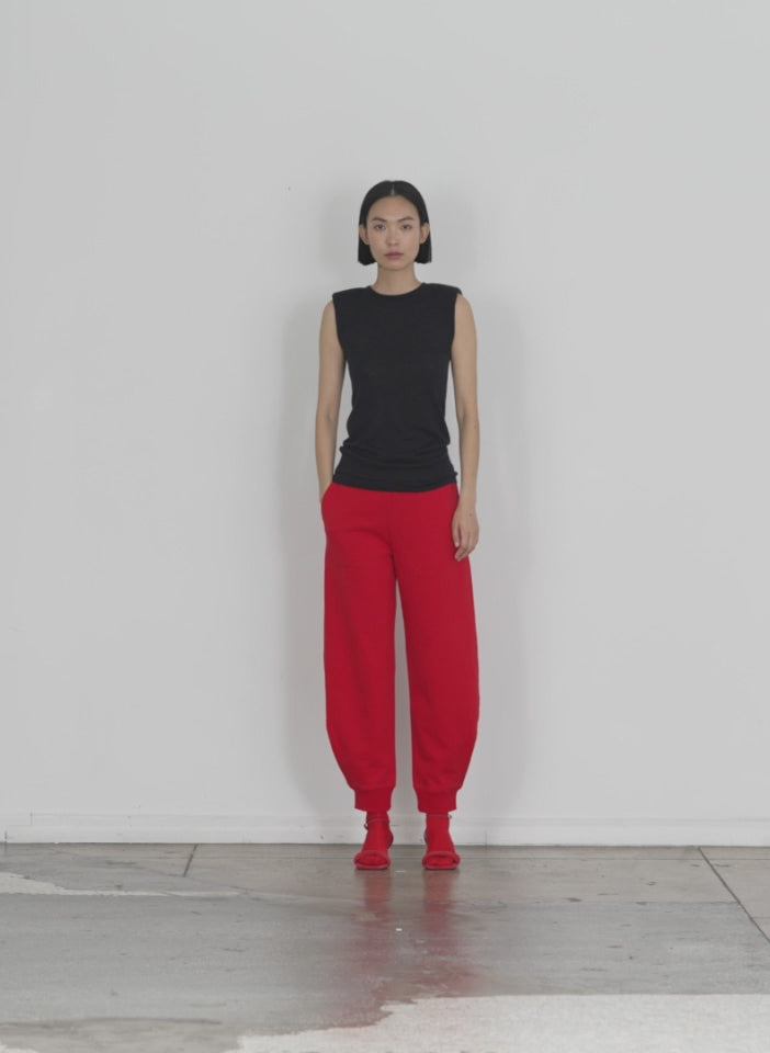 Model wearing the calder sweatpant red walking forward and turning around