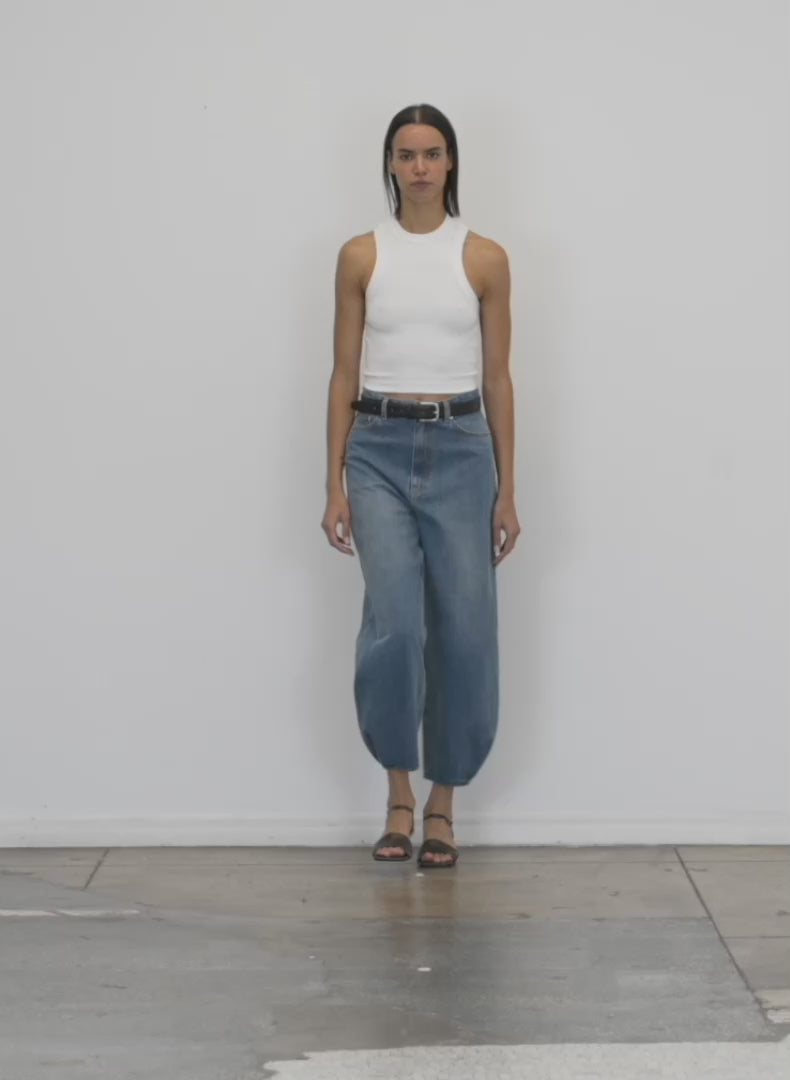 Model wearing the ribbed t cropped tank white 1 walking forward and turning around