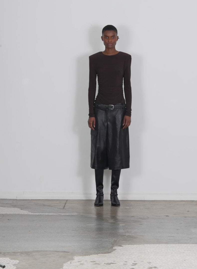 Model wearing the micro jersey shoulderpad fitted crewneck top dark brown walking forward and turning around