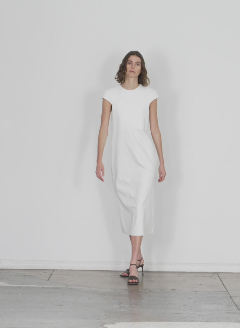 Model wearing the compact ultra stretch knit lean sleeveless dress white walking forward and turning around