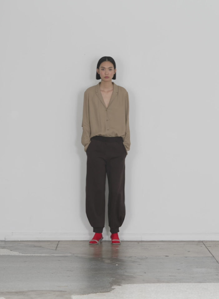 Model wearing the calder sweatpant brown walking forward and turning around