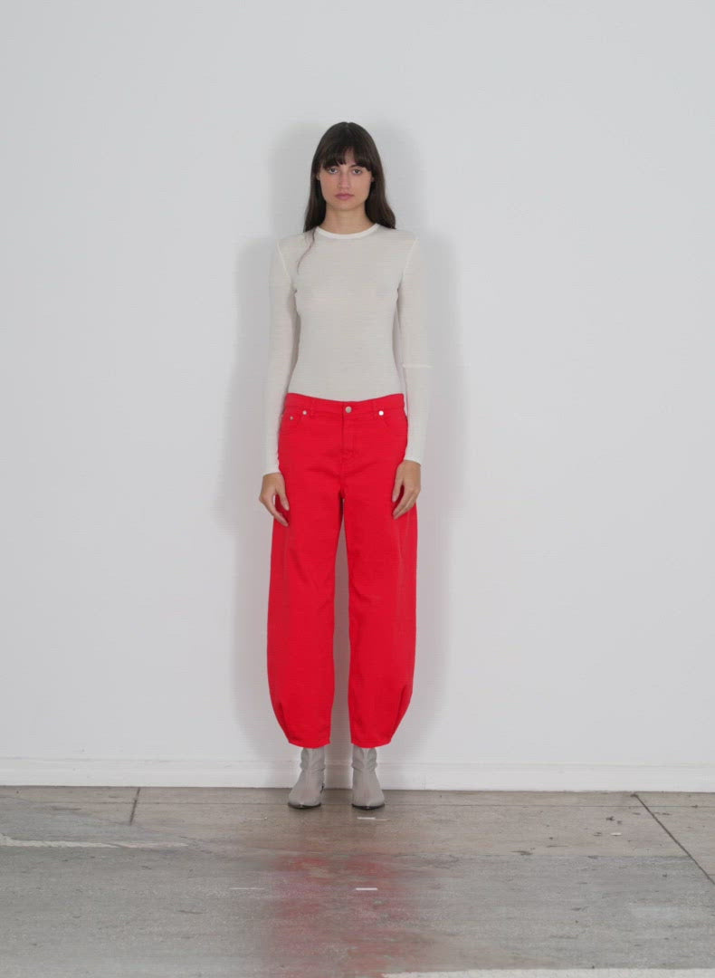 Model wearing the garment washed twill brancusi pant red walking forward and turning around