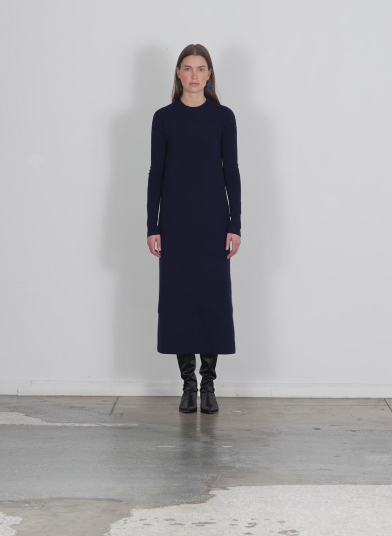 Model wearing the compact stretch cashmere dress navy walking forward and turning around