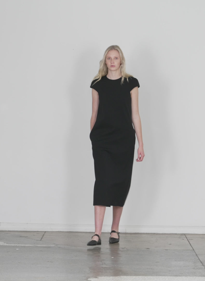 Model wearing the compact ultra stretch knit lean sleeveless dress black walking forward and turning around
