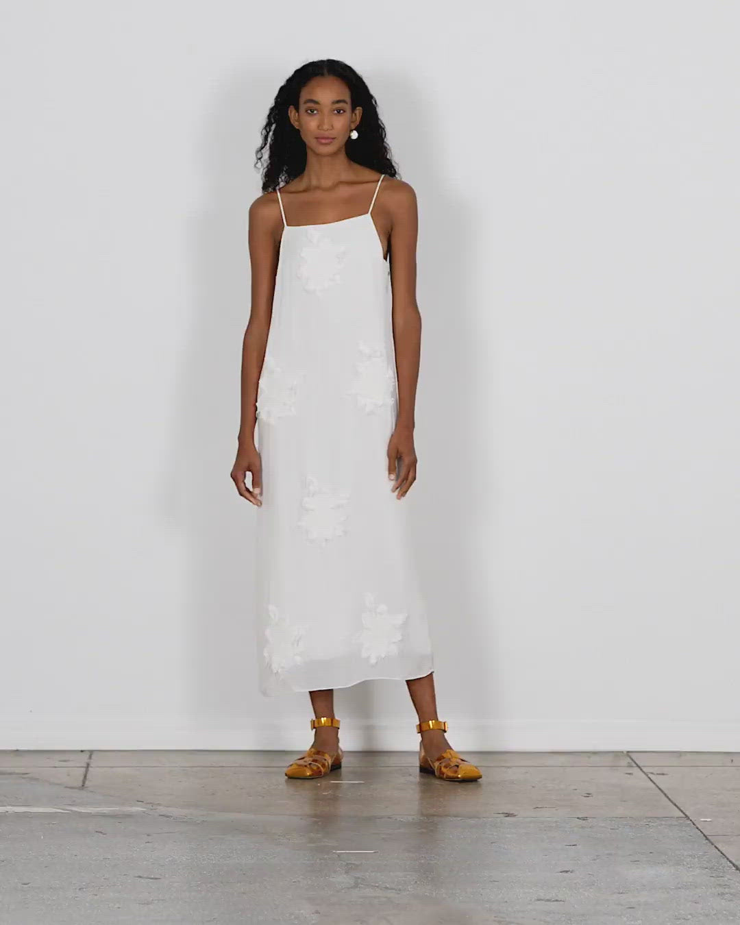 Model wearing the dahlia fil coupe slip dress walking forward and turning around