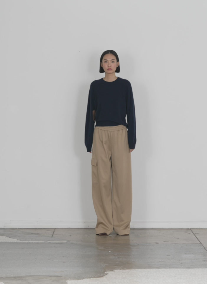 Model wearing the featherweight cashmere sweater open sleeve cocoon navy walking forward and turning around