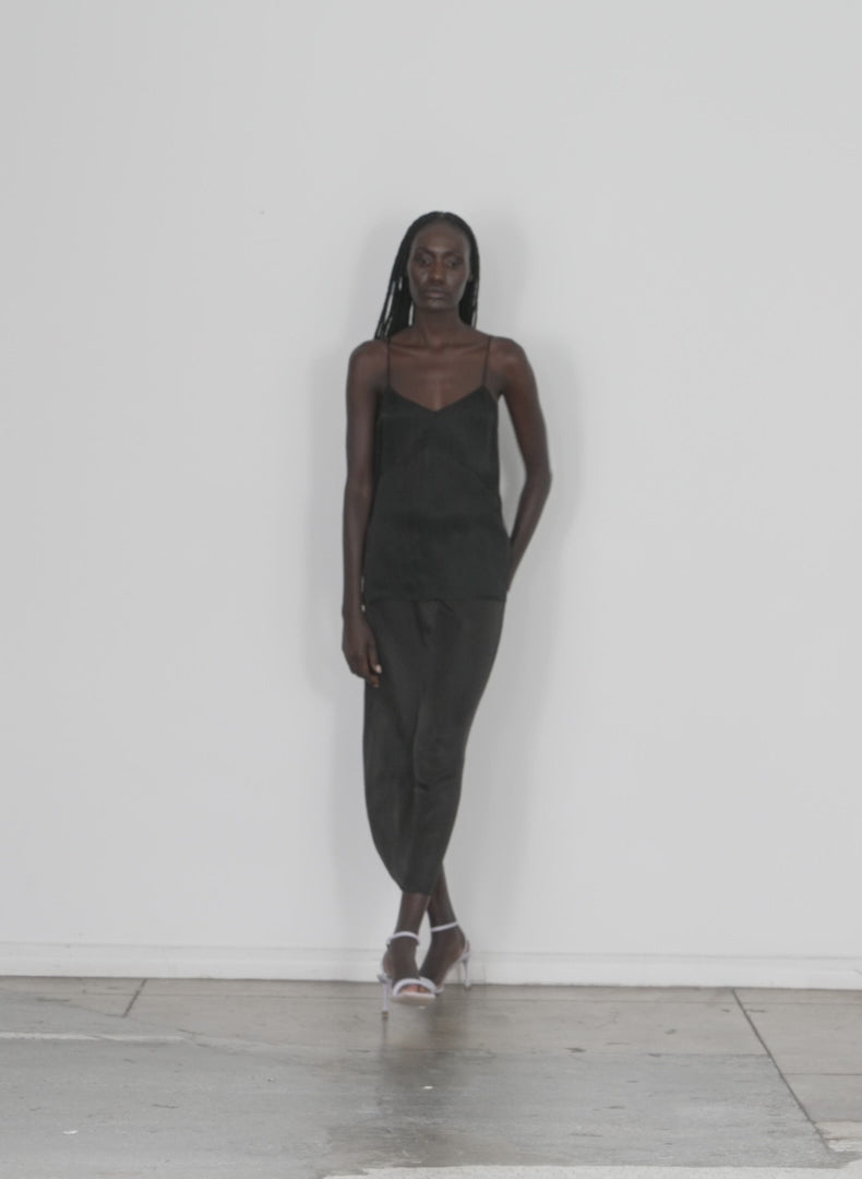 Model wearing the the slip skirt black walking forward and turning around