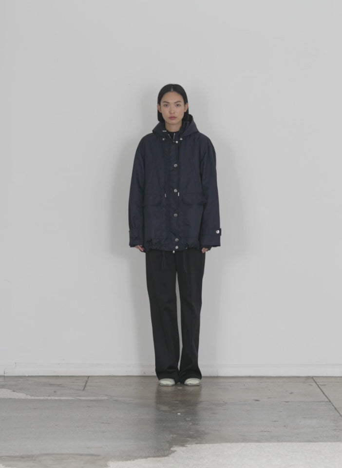 Model wearing the eco nylon anorak midnight navy walking forward and turning around