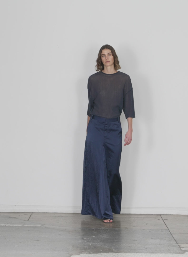 Model wearing the luxe eco satin godet maxi skirt navy walking forward and turning around