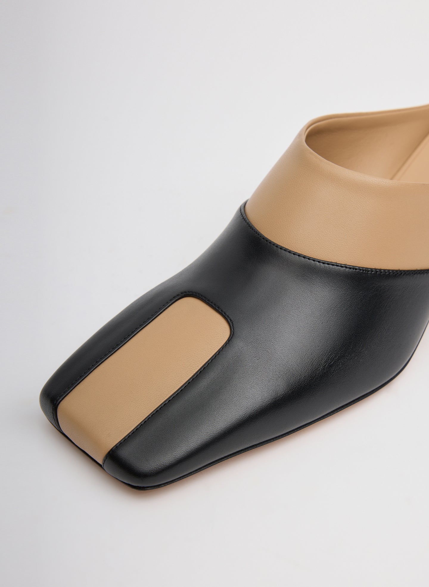 Two Tone Beige and Black Leather Gwinnett Heeled Mules - closeup of two tone toe