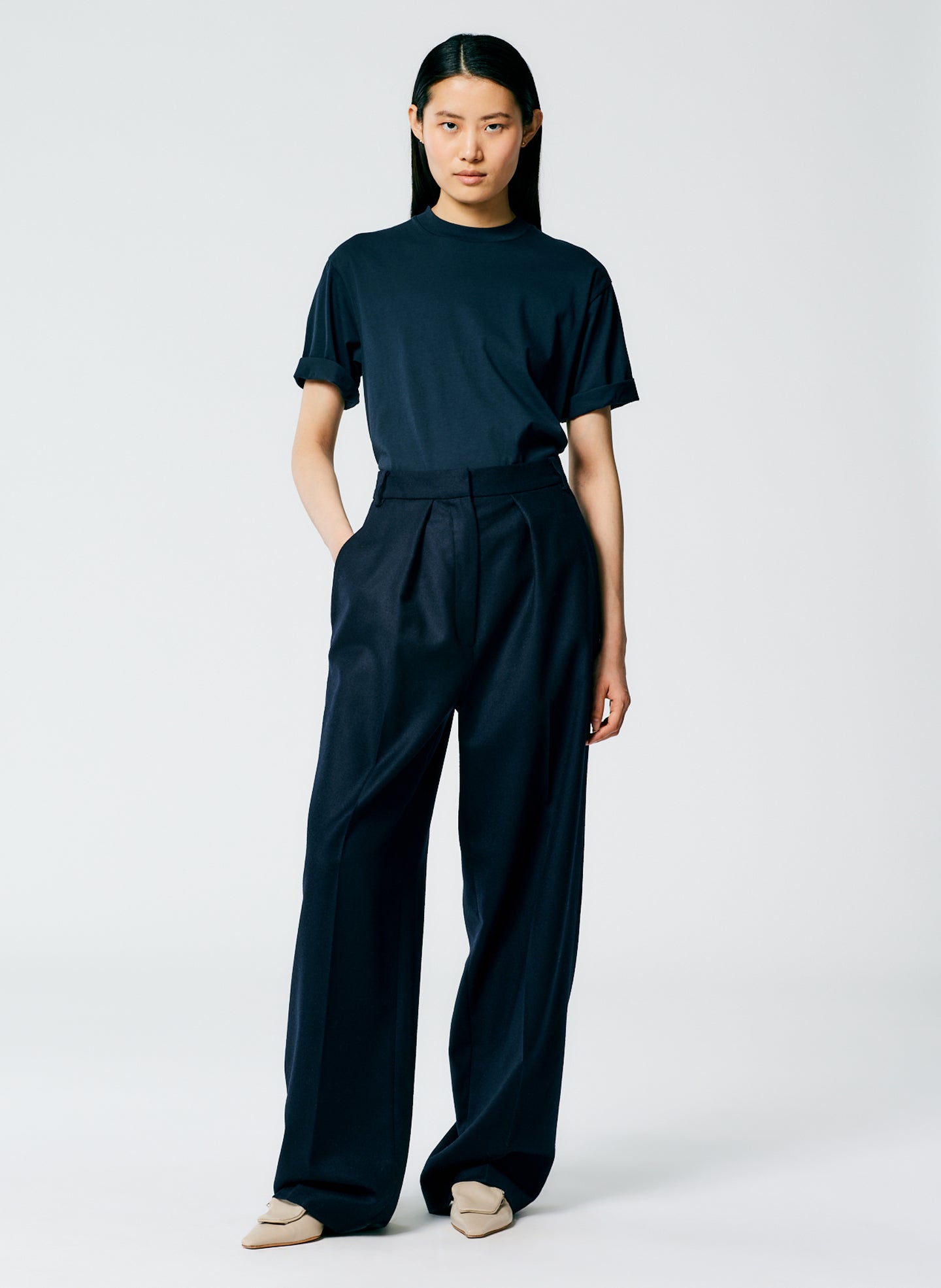 Black mock-neck T-shirt with a raised close-fitting collar and wide trousers
