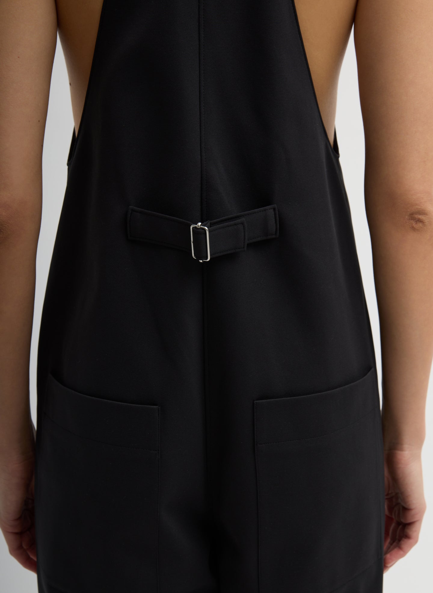 Black Compact Tech Knit Overalls - closeup of back belt detail