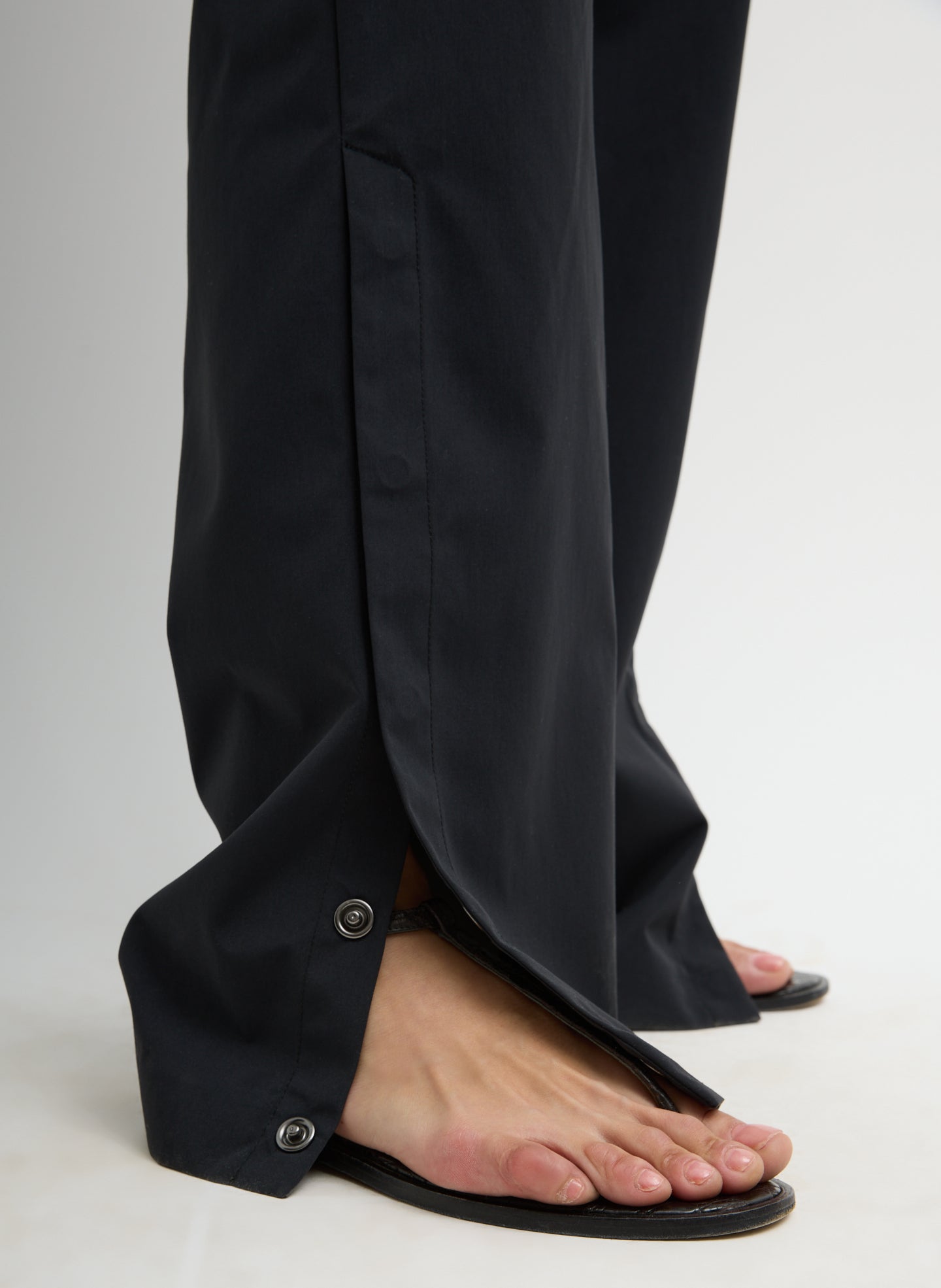 Black Tech Suiting Mark Trouser - closeup of snap details at hem
