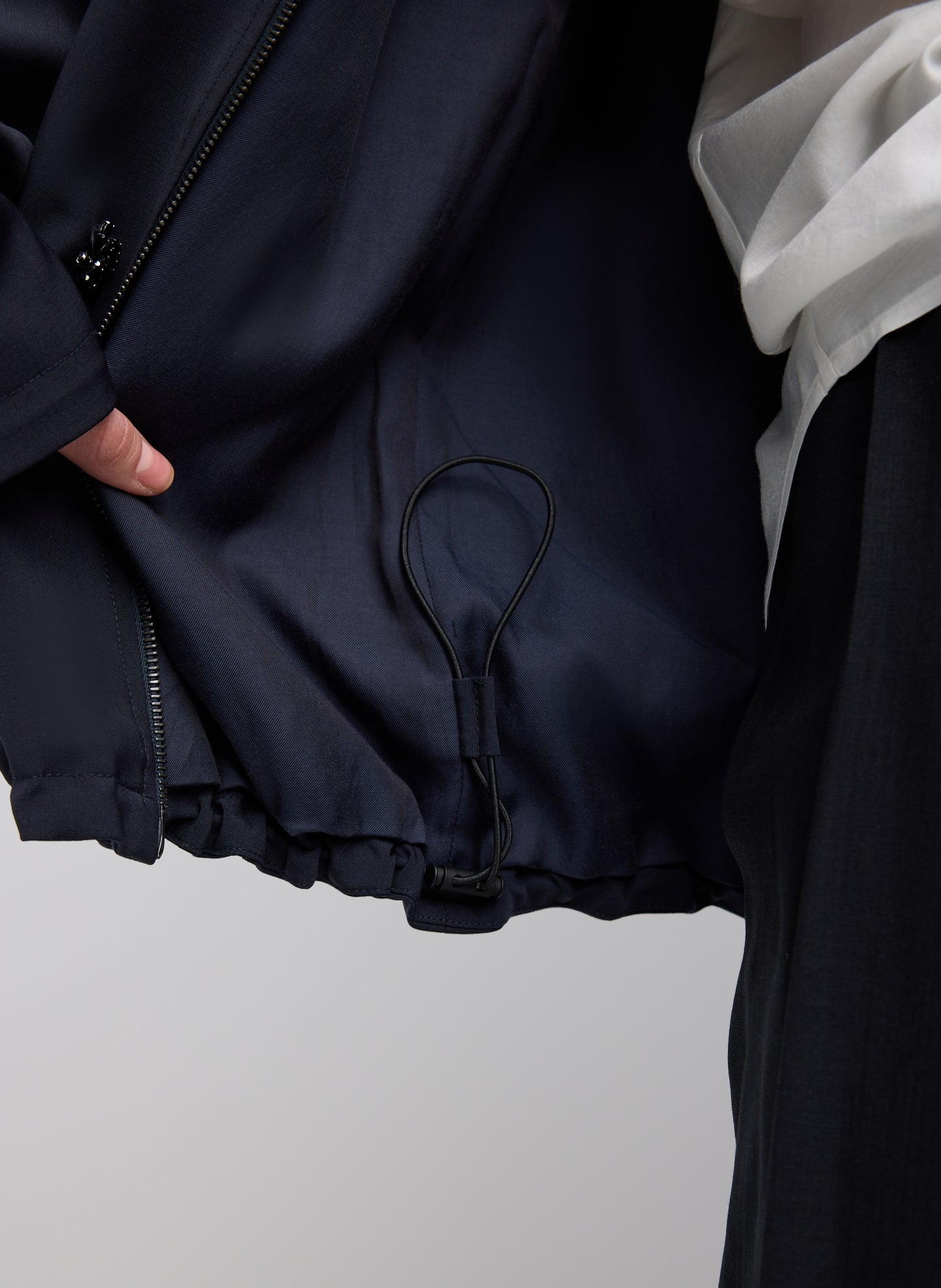 Black Tropical Wool Beaded Bomber Jacket - closeup of drawstring detail at hem