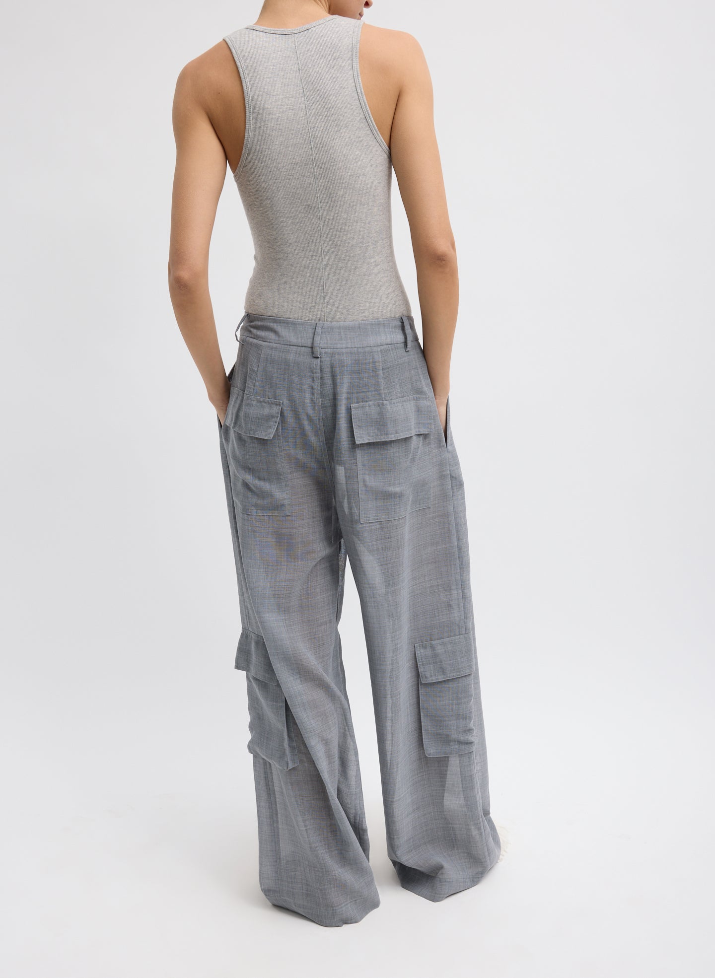Heather Grey Sheer Wool Gauze Triple Pleat Pant –  sheer, back view on model with hands in pockets  