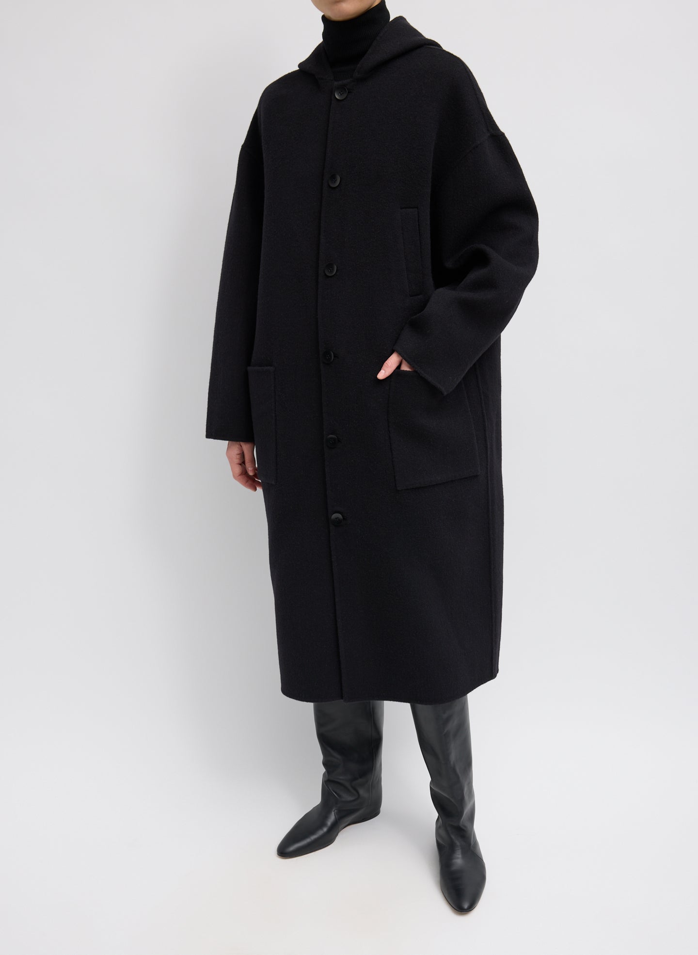 Black Luxe Double Faced Wool Angora Hooded Coat – relaxed fit, full look, front view on model with hand in pocket 