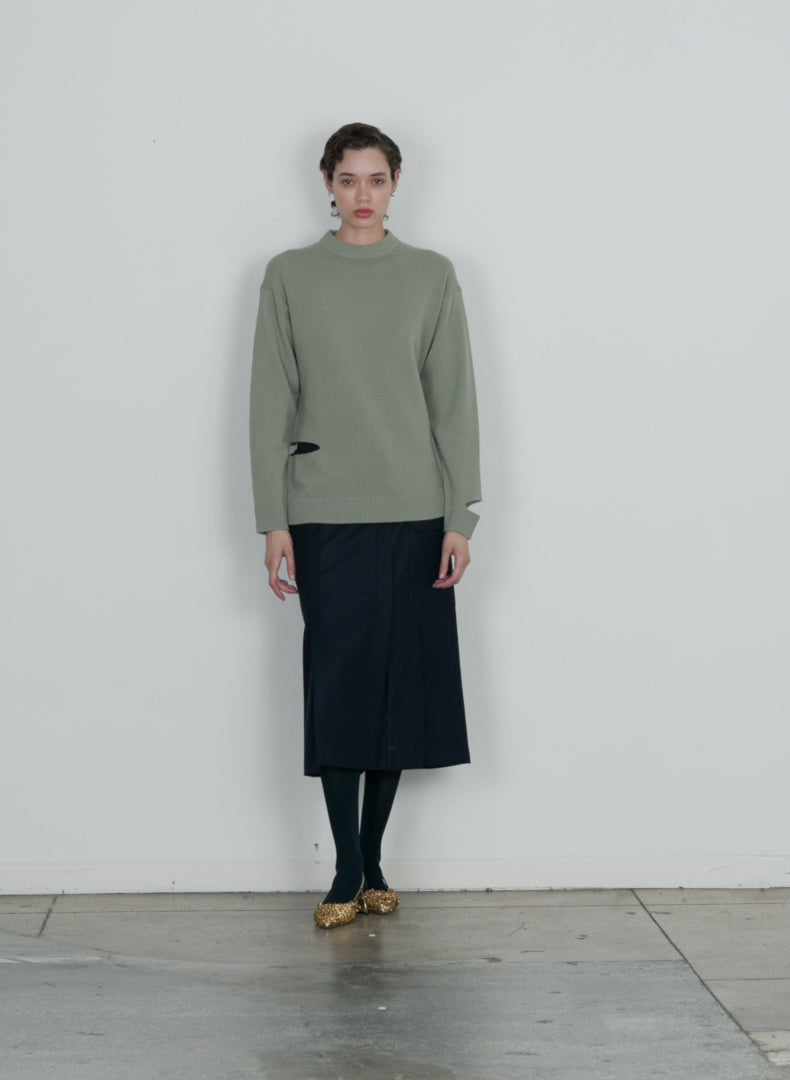 Model wearing the soft lambswool crewneck easy pullover pale olive walking forward and turning around