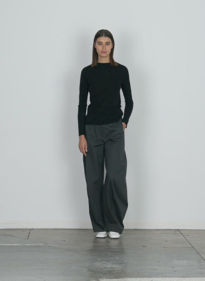 Model wearing the skinlike mercerized wool soft sheer pullover charcoal walking forward and turning around