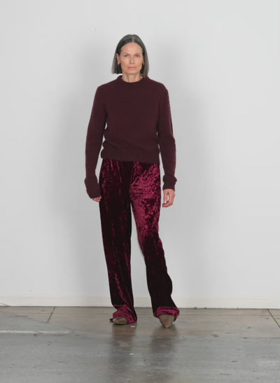 Model wearing the stretch velvet wide leg pullon pant garnet walking forward and turning around