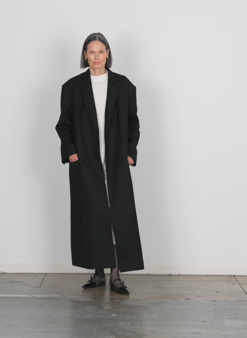 Model wearing the luxe tuxedo maxi tux coat black walking forward and turning around